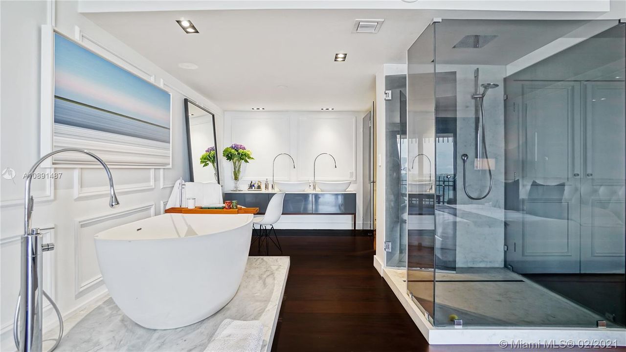Modern Zen Luxury Master Bathroom with dual sinks, rain shower, Gessi freestanding soaking tub; Gessi Goccia faucets, Carrara marble custom shower and tub base and separate water closet.