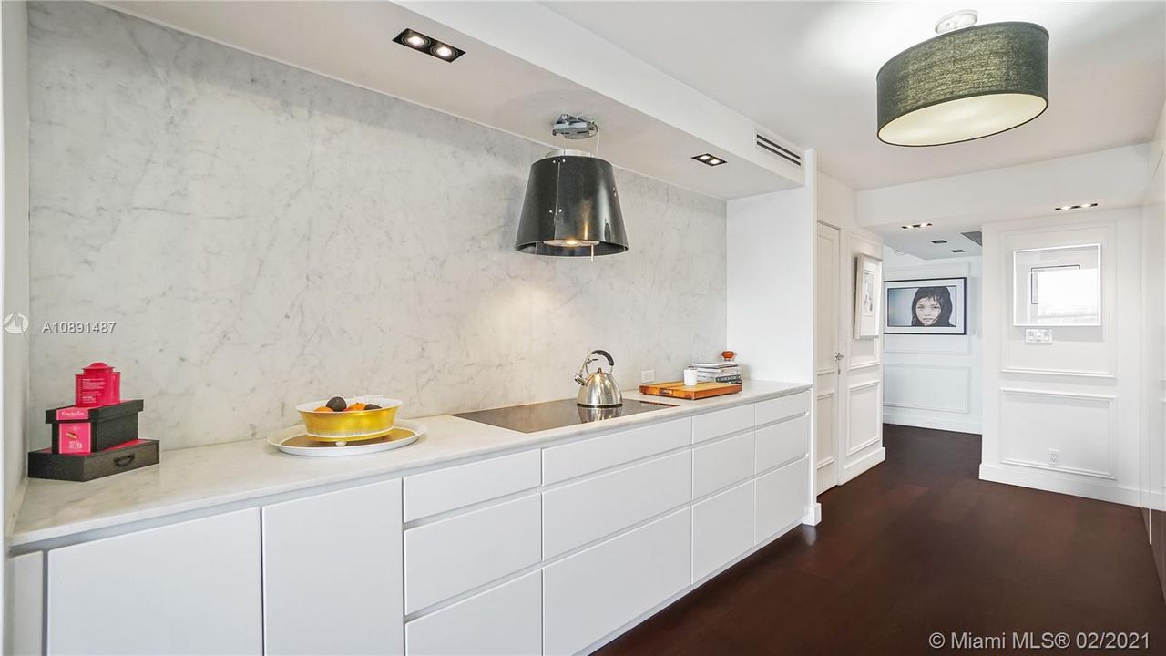 Modern Luxury Poggenpohl kitchen with signature white lacquer cabinets. Carrara marble counter tops and backsplash wall refine this elegant space.  Sub-Zero Wolf and Gaggenau appliances and minimalist decorative Elica Platinum design Eco-efficient hood.