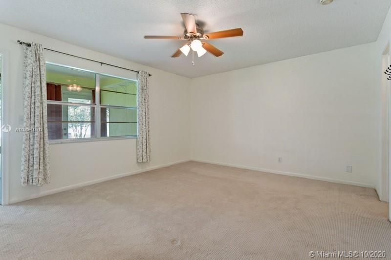 Master bedroom with windows looking in at the Florida room