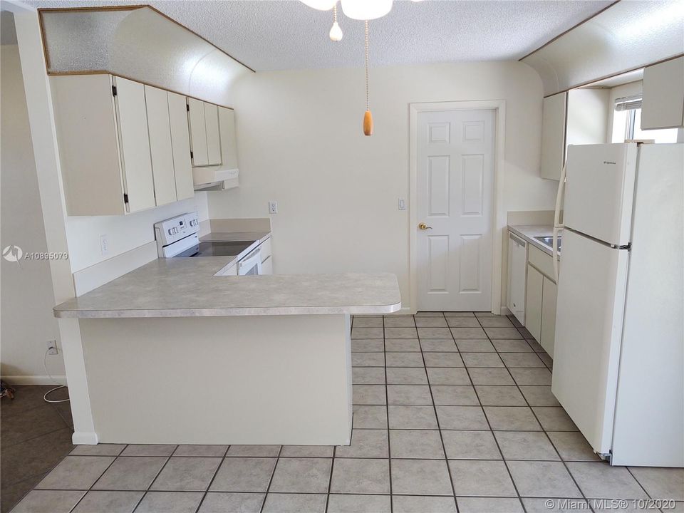 Kitchen with ample counter space and upper and lower cabinets. New refrigerator.  Laundry room is adjacent with full size washer and dryer.  New hot water heater is in laundry room.