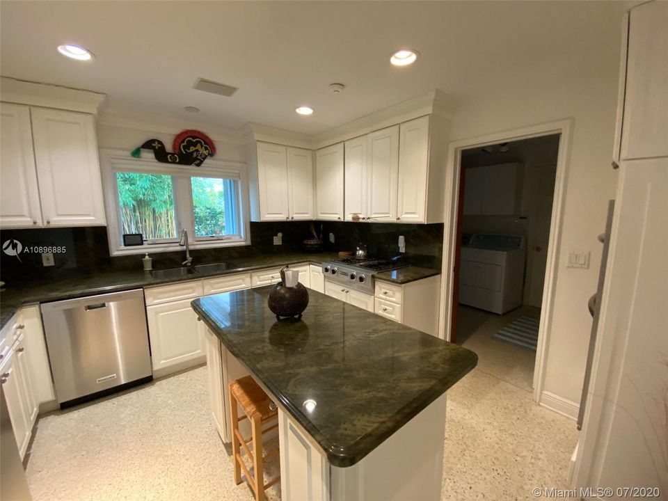 KITCHEN COMES EQUIPPED WITH GAS STOVE AND DOOR LEADS INTO LAUNDRY ROOM AND GARAGE AREA