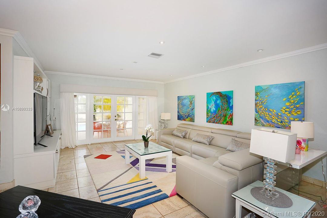 The living room area with doors that open up to the beautiful pool area.