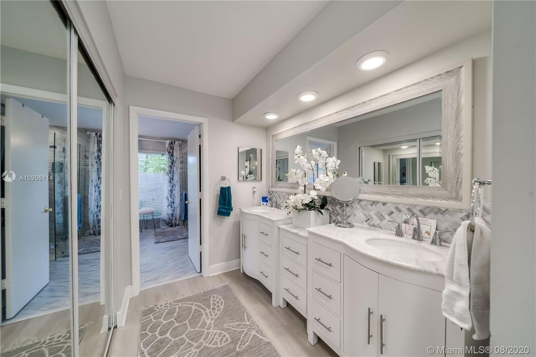 Double Vanity with lots of storage, custom mirror & backsplash with recessed lighting.