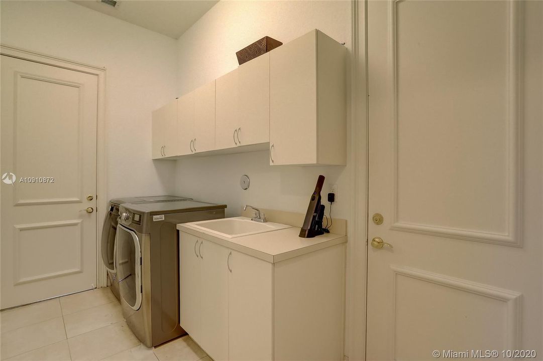 Laundry Room w/ newer washer / dryer and sink. Huge under stair storage closet next to it. Leads to garage