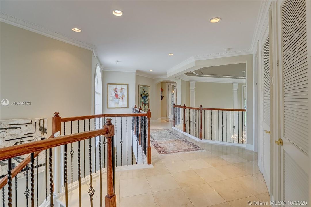 Bright / open catwalk w/ wrought iron & wood railings, marble floors in common areas