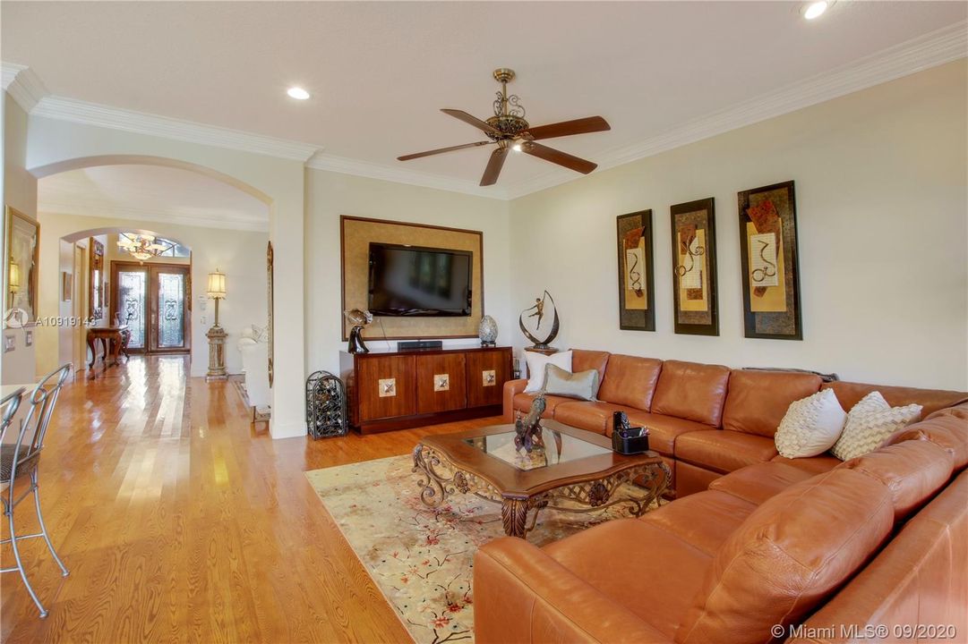 LIVING ROOM ADORNED WITH CUSTOM CROWN MOLDING AND HIGH BASEBOARD MOLDING