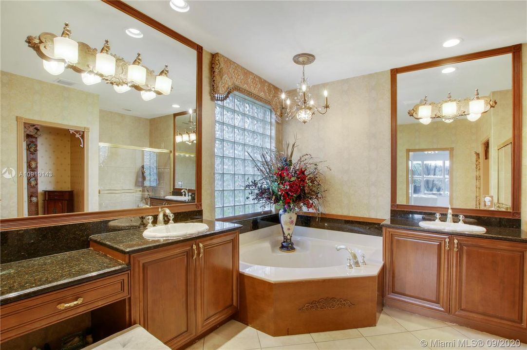 LARGE MASTER BATHROOM WITH HIS AND HER VANITIES WITH GRANITE COUNTERS AND ROMAN TUB