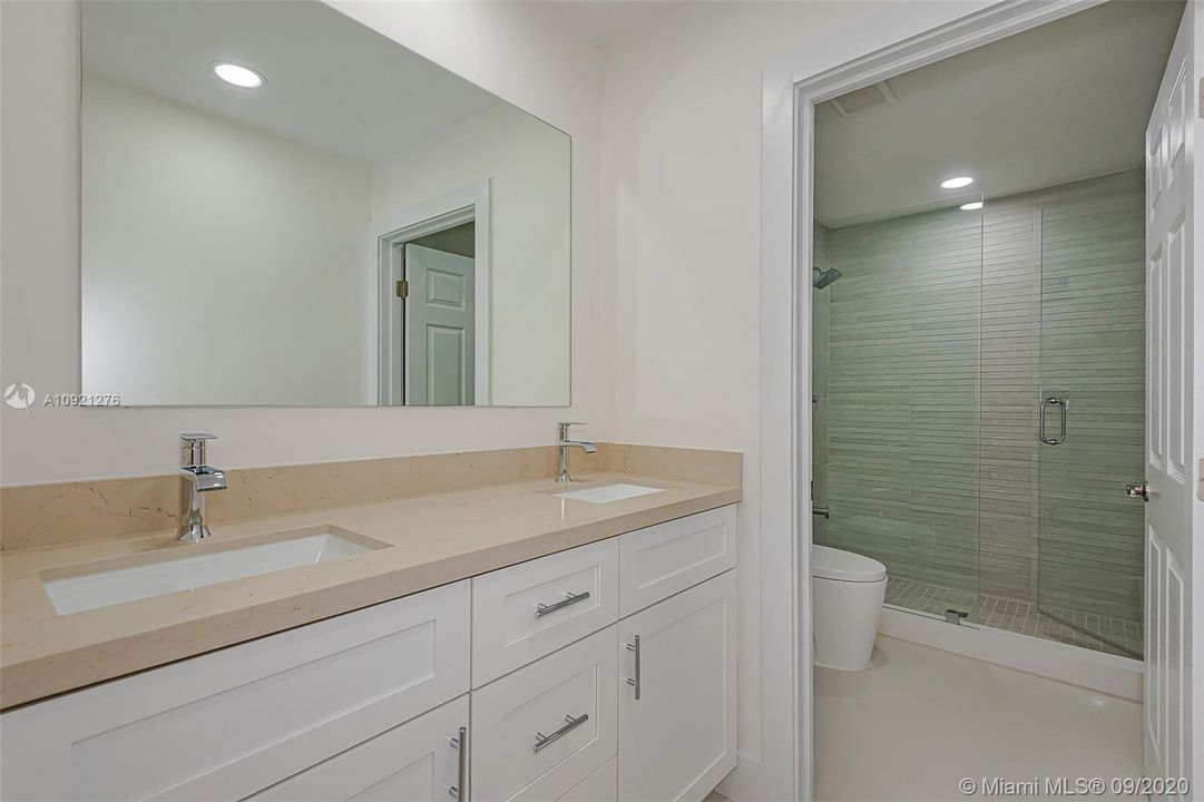 Brand new master bathroom features double sinks, vanity and glass shower