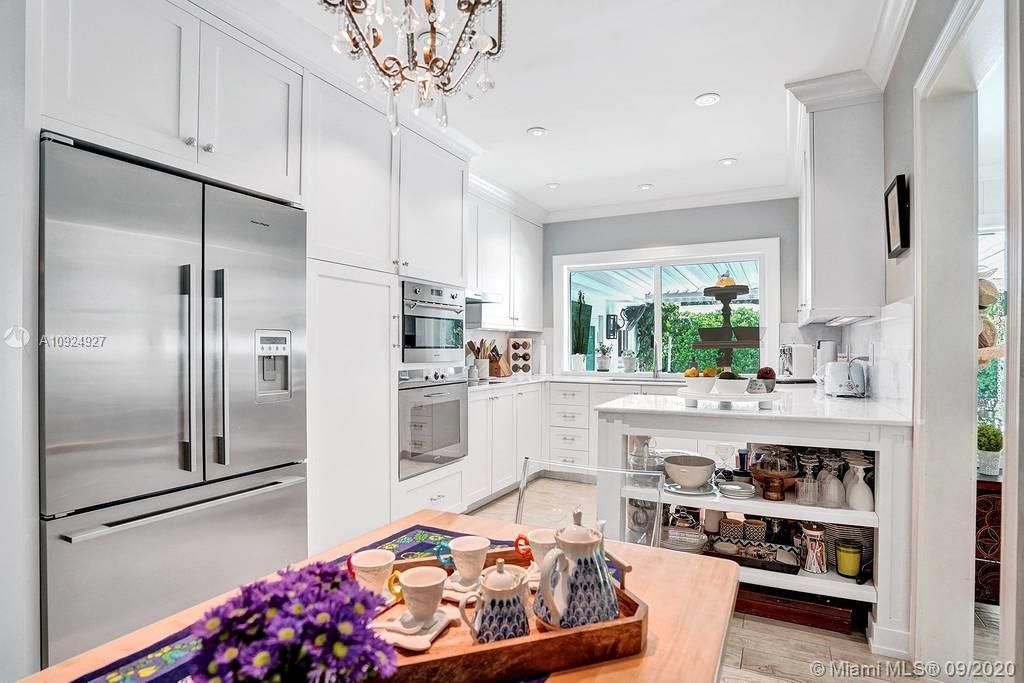 Bright white kitchen with european stainless steel appliances