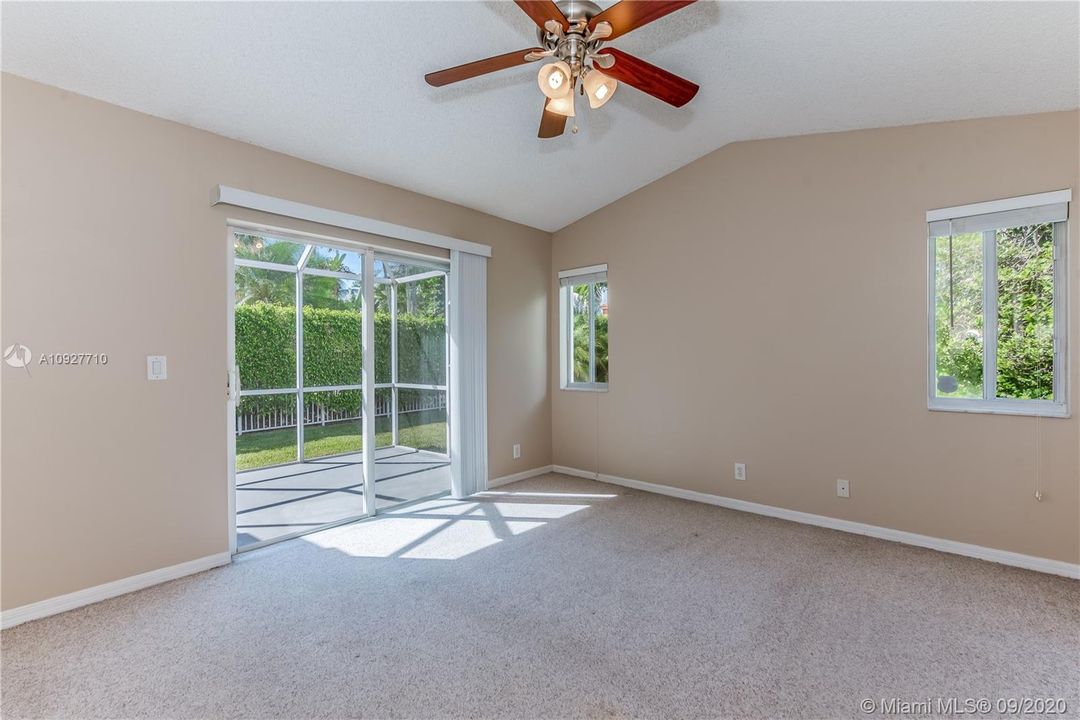 Bright, Master-bedroom with sliding glass doors to patio and high ceilings.