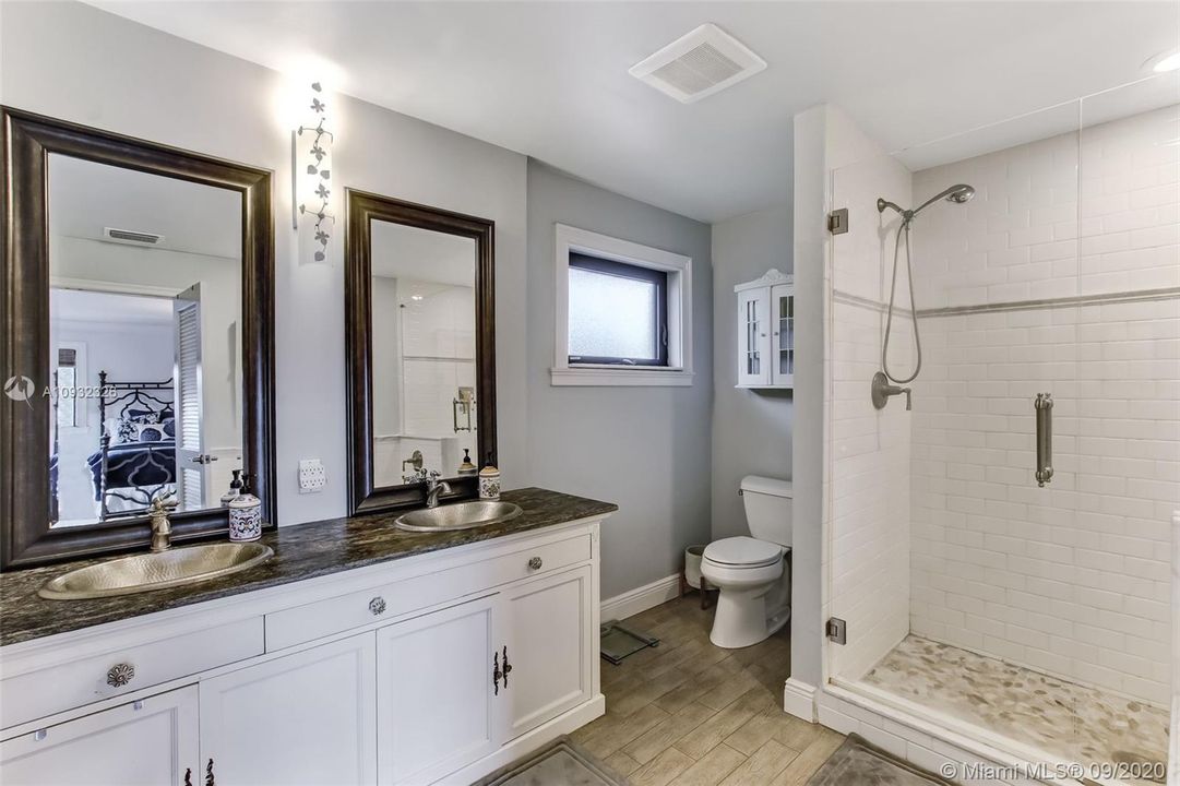 Master Bathroom remodeled with additional closet added; custom vanity with leathered granite and hammered brushed nickel sinks.