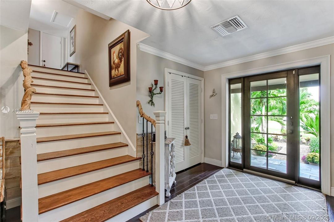 Foyer with PGT impact front door and side windows.