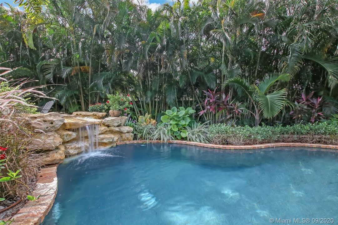 Large free form pool with calming water features and peaceful surroundings.