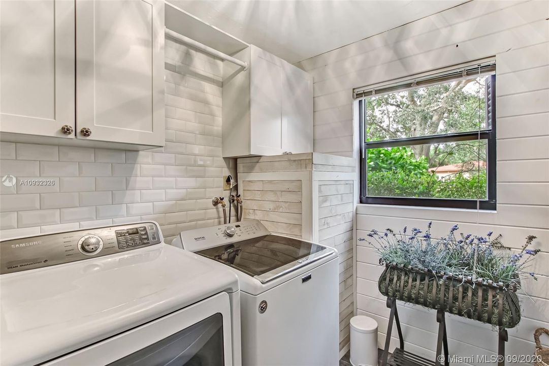 Laundry room with a custom A/C door, custom water heater cover, shiplap walls, subway tile backsplash, tile flooring and Ecobee WiFi thermostat.