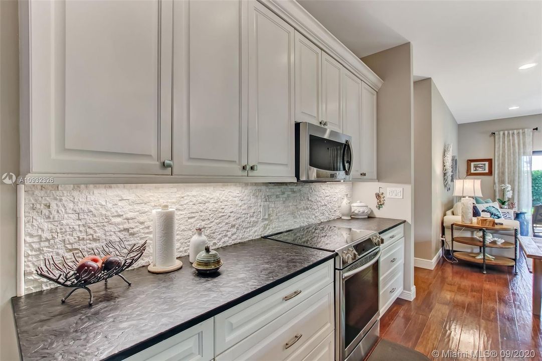 Guest house kitchen with custom cabinetry and unique storage areas.  Wood flooring throughout.