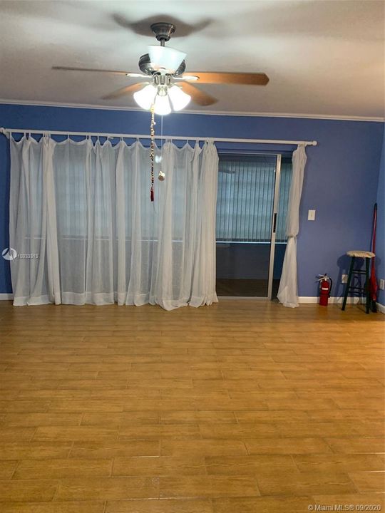 living dining area leading to enclosed family room.  Note beautiful tile floors