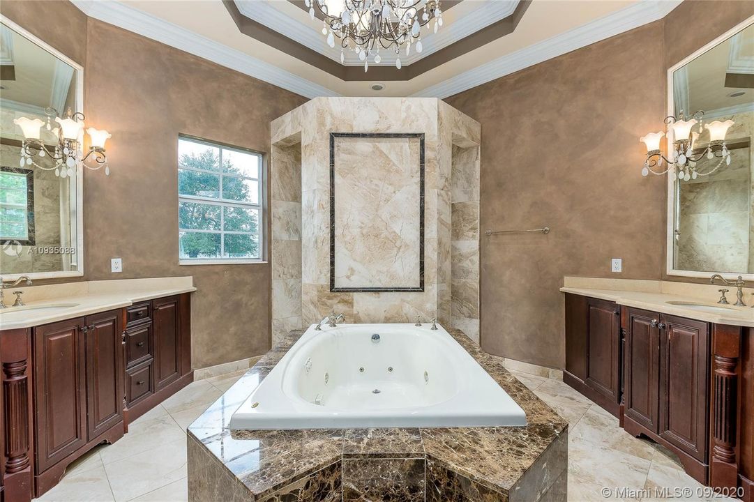 PRIMARY BATHROOM WITH HIS/HERS SINKS, WHIRLPOOL TUB AND MARBLE ENCLOSED SHOWER