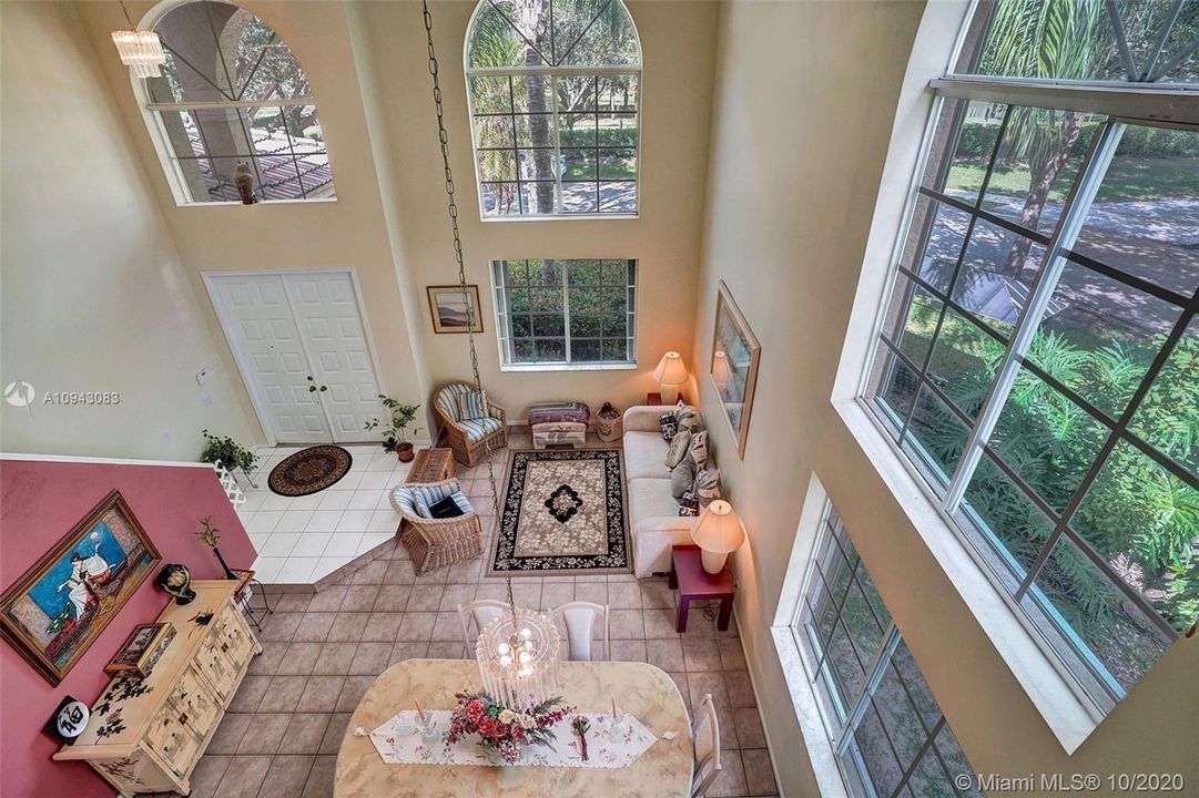 Enter into a living room/dining room with soaring 18' ceilings and bursting with sunlight through the arched clerestory windows.