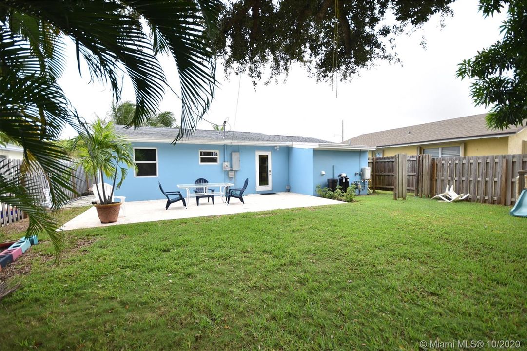 Lots of green space and patio in backyard including Mango Tree