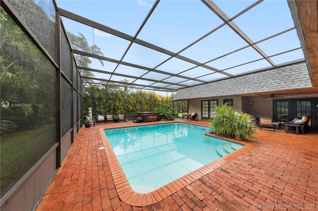 LARGE RESORT STYLE POOL & AN ADJACENT SPA W/ PAVERED POOL DECK, SUMMER KITCHEN W/ BEVERAGE REFRIGERATOR/SINK, FRENCH DOORS LEADING INTO FAMILY ROOM, KITCHEN, MAIN SUITE, & GUEST BEDROOM.
