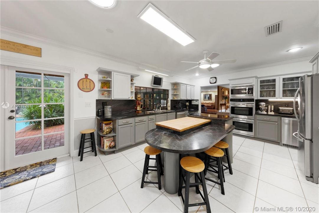 VIEW OF CHEFS KITCHEN W/ FRENCH DOORS LEADING TO THE POOL.