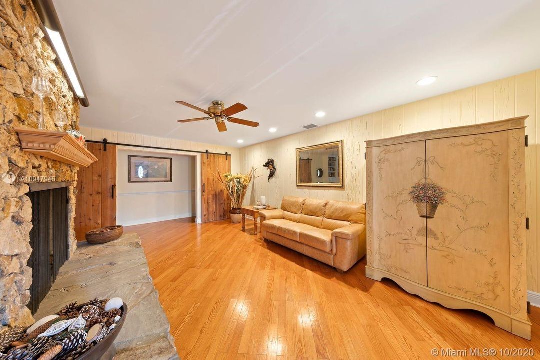 LIVING ROOM W/ VIEW OF BARN DOORS LEADING TO THE 3 BEDROOM "WING" OF THE HOUSE.