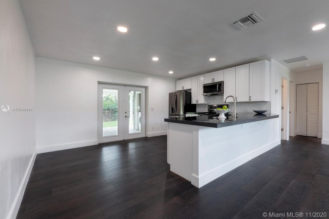 Eat in kitchen- Concrete Countertops with Black Epoxy Finish. French Doors open to Porch