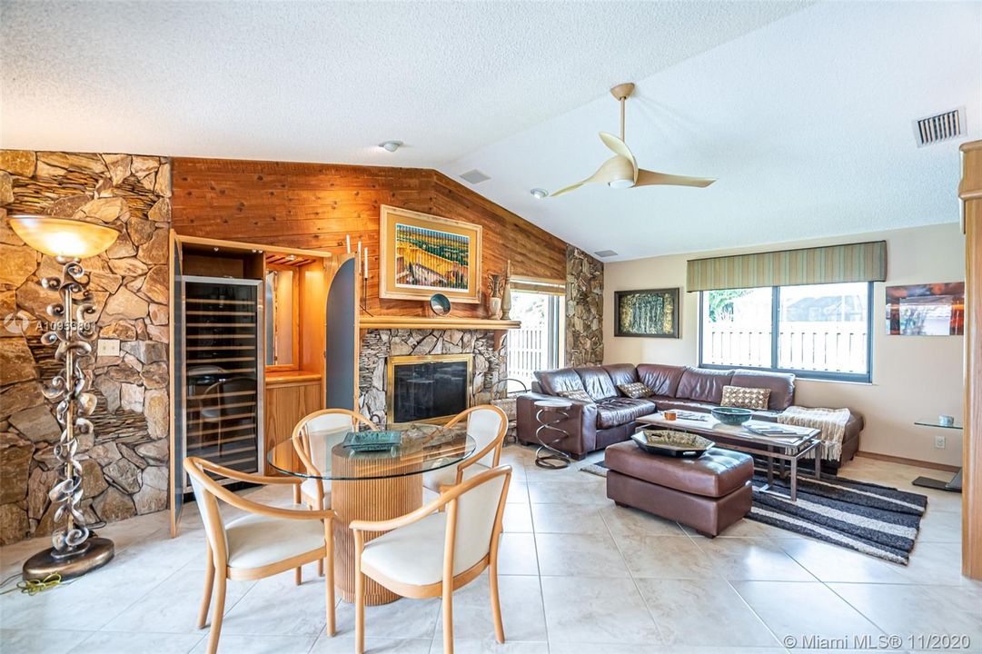 Family room with custom built in wall unit, wet bar & wine cooler complete with fireplace