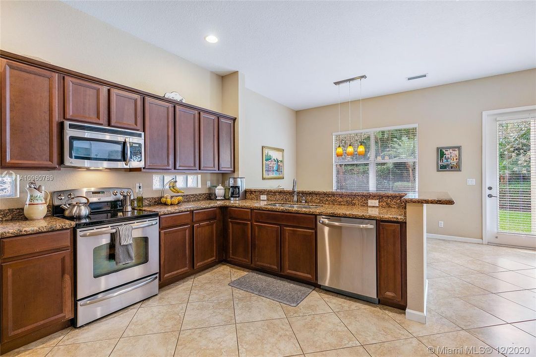 Kitchen with stainless steel appliances, granite countertops -breakfast bar and dining area. Ceramic tile floors and wood blinds. 10' ceiling on first floor.