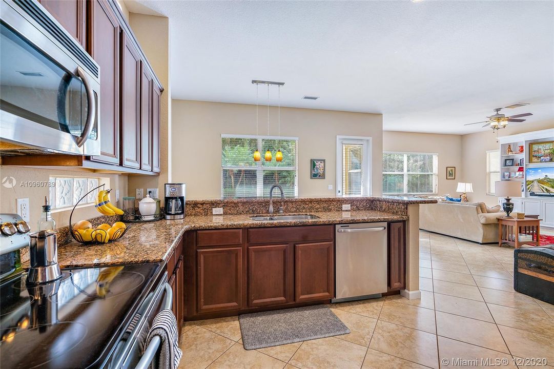 Kitchen with stainless steel appliances, granite countertops -breakfast bar and dining area. Ceramic tile floors and wood blinds. 10' ceiling on first floor.