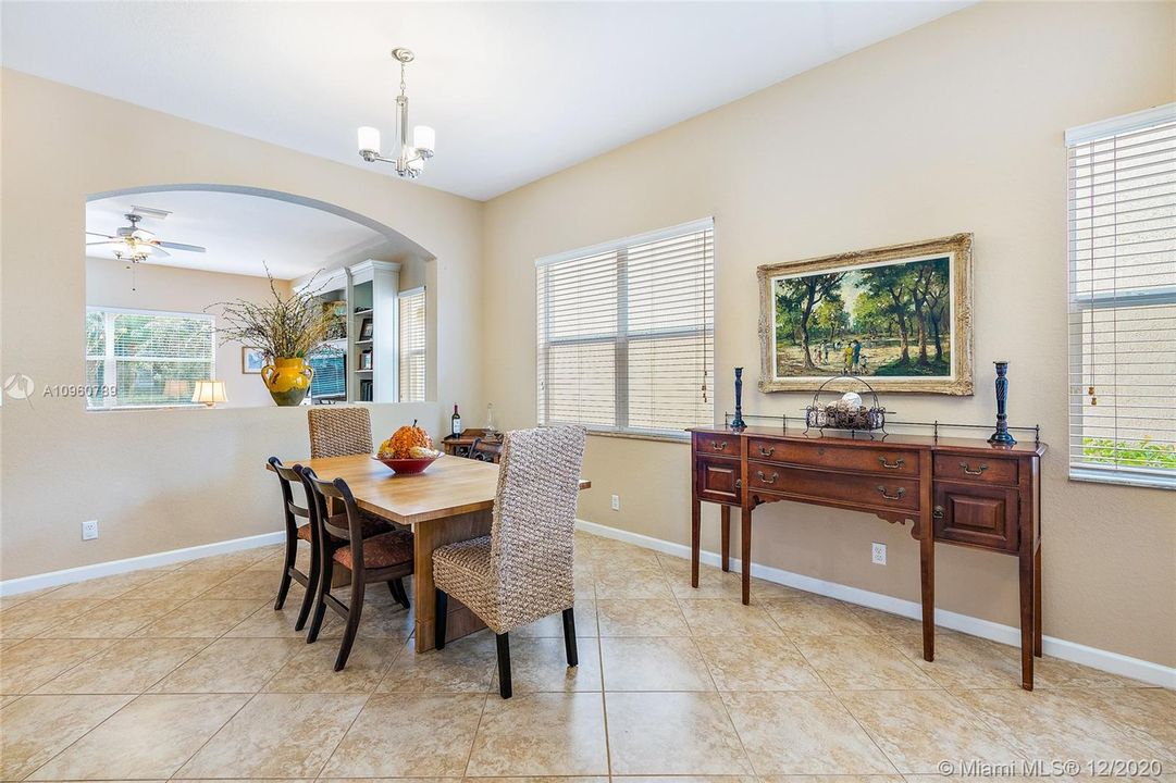 Dining room area with ceramic tile floors and wood blinds. 10' ceiling on first floor.