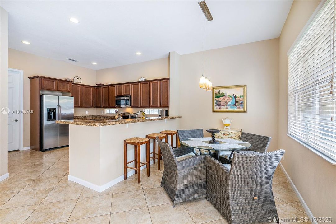 Kitchen with stainless steel appliances, granite countertops -breakfast bar and dining area. Ceramic tile floors and wood blinds. 10' ceiling on first floor.