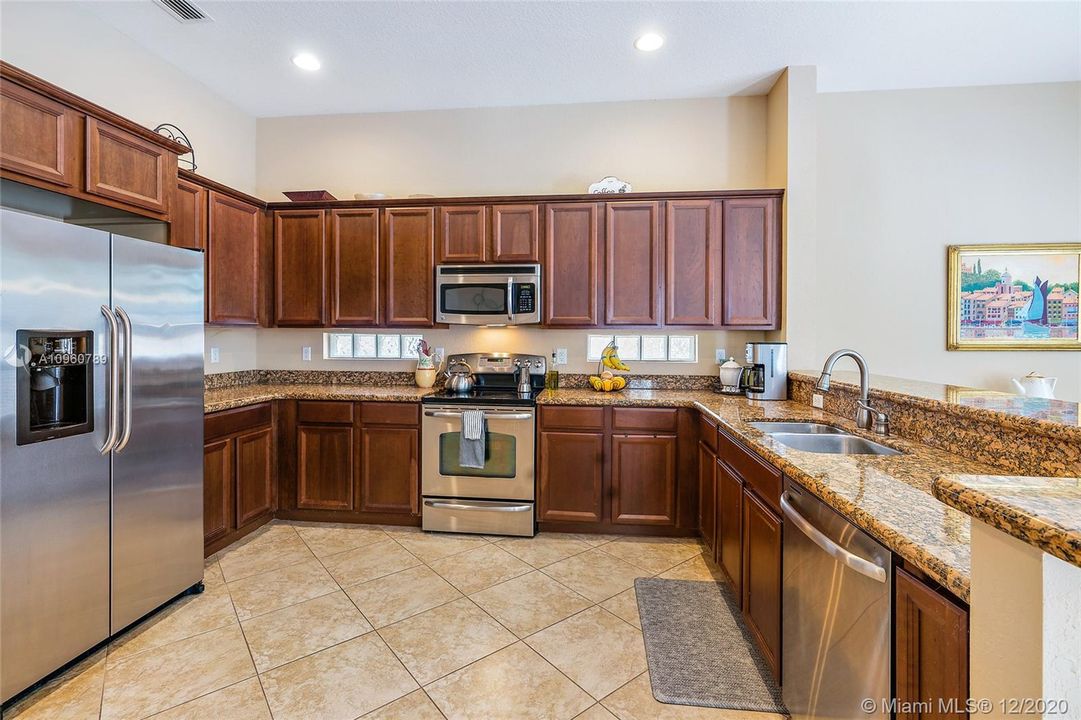 Kitchen with stainless steel appliances, granite countertops -breakfast bar and dining area. Ceramic tile floors and wood blinds. 10' ceiling on first floor.