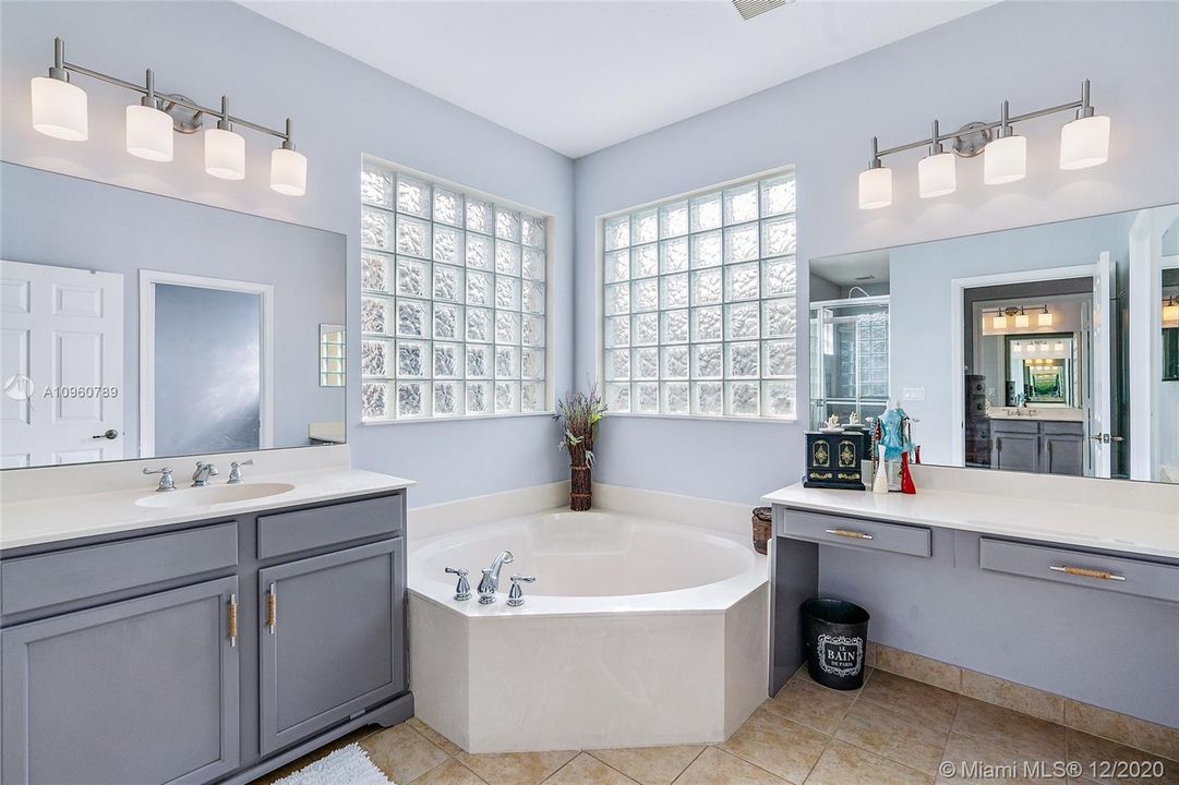 Master bathroom with adjoining walk thru shower dual vanities and roman tub.