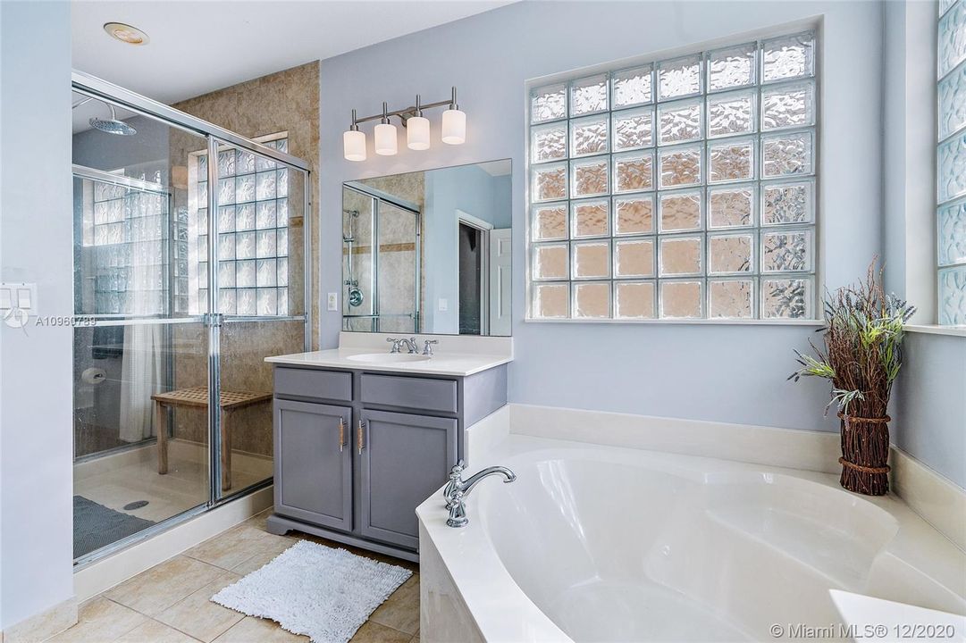 Master bathroom with adjoining walk thru shower dual vanities and roman tub.