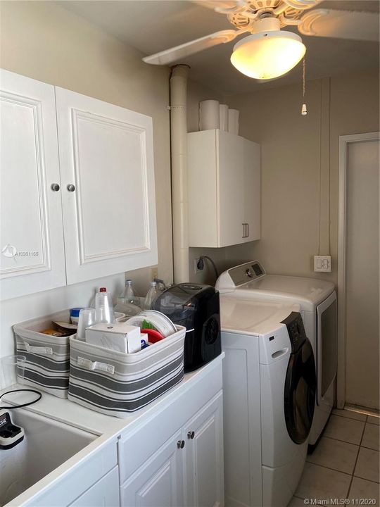 Laundry room with built-in cabinets and sink