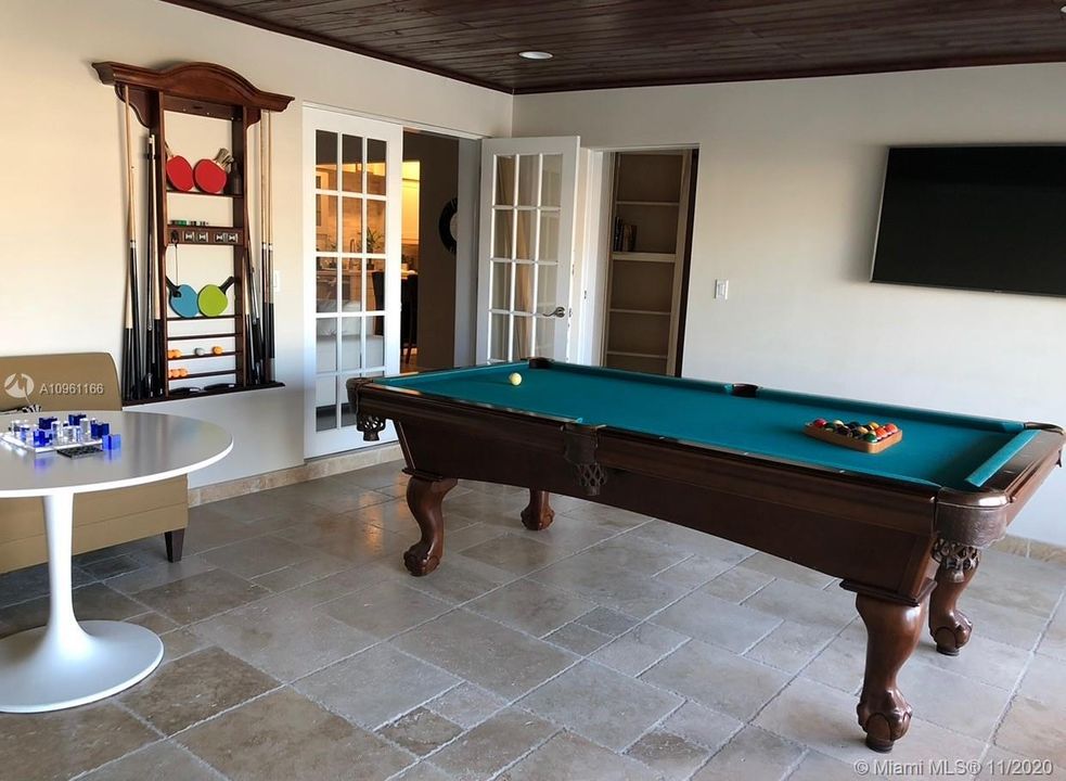 Game Room with travertine and wood ceiling details same as patio for indoor / outdoor flow.