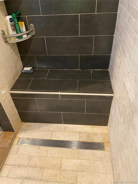Shower with built-in seating and beautiful contrasting tile work.