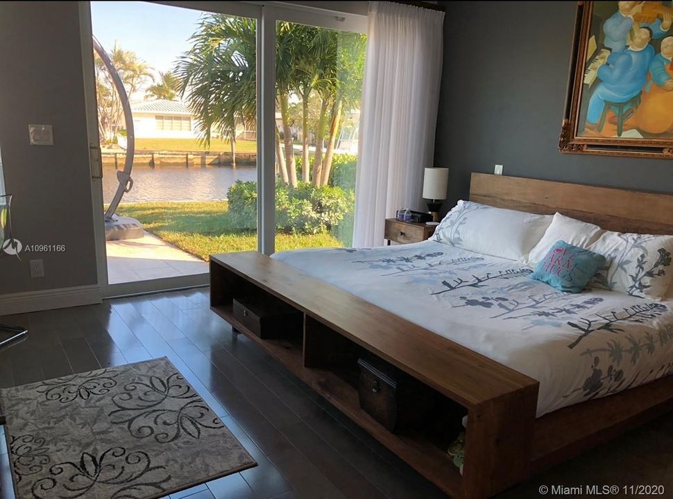 Master bedroom - wood floors, sliding doors to patio, view of the canal.