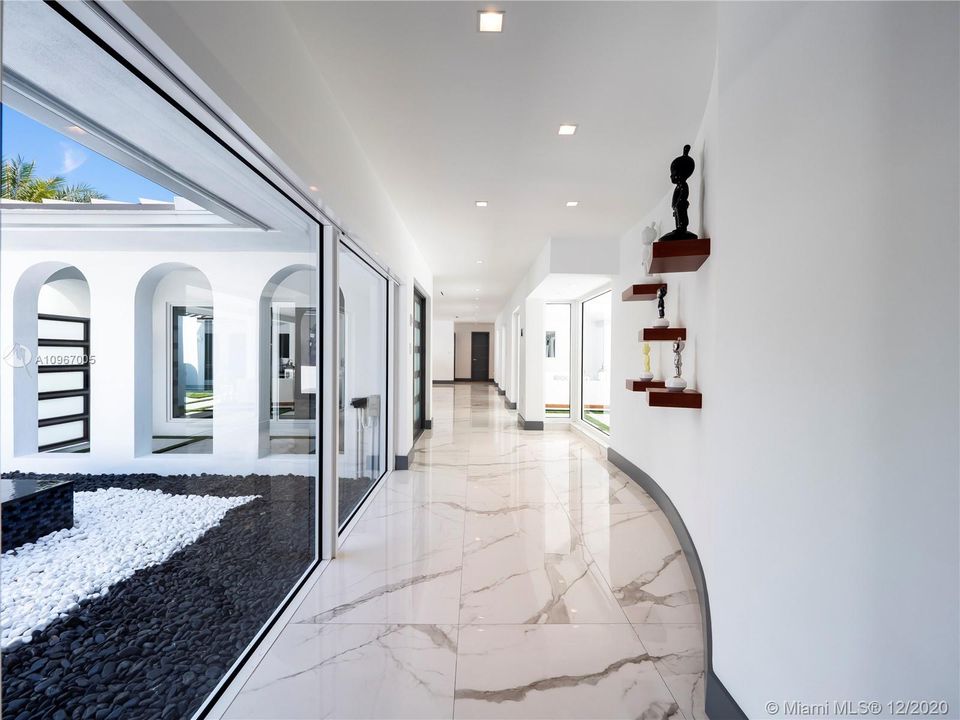 Carrara marble-look 30 x 60 porcelain tiles throughout common areas.