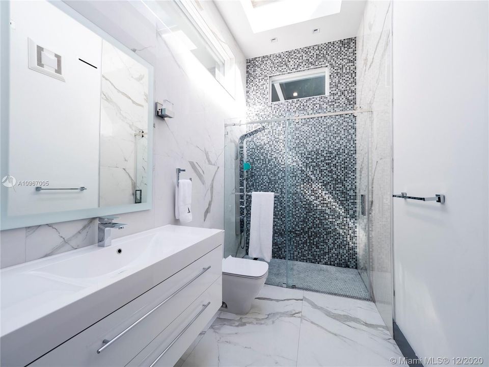 Full bath with skylight shared by bedrooms #2 and #3.