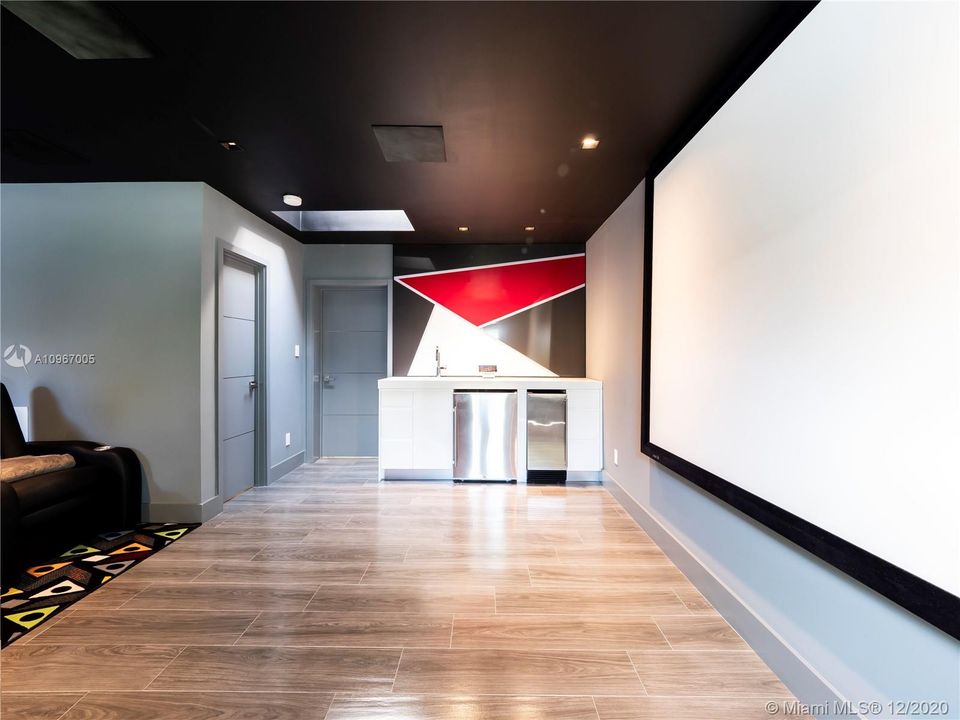 Media room with built-in bar, refrigerator, sink and ice-maker.  Doors lead to bedroom #1 and full bathroom.