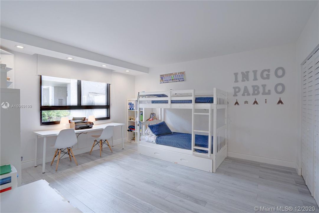 Bright and spacious bedroom with updated lighting and floors, featuring  wall-to-walll closet space.