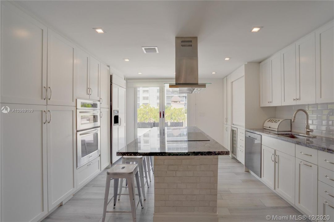 Island kitchen in an open floor-plan with direct access to the inviting oversized terrace feels like a home.