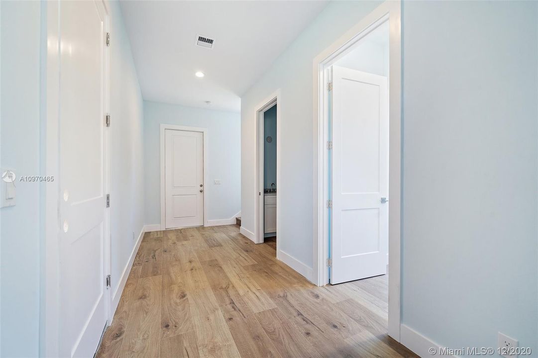 Foyer area with doors to the right leading to laundry room and half bathroom and the left door leading into the garage