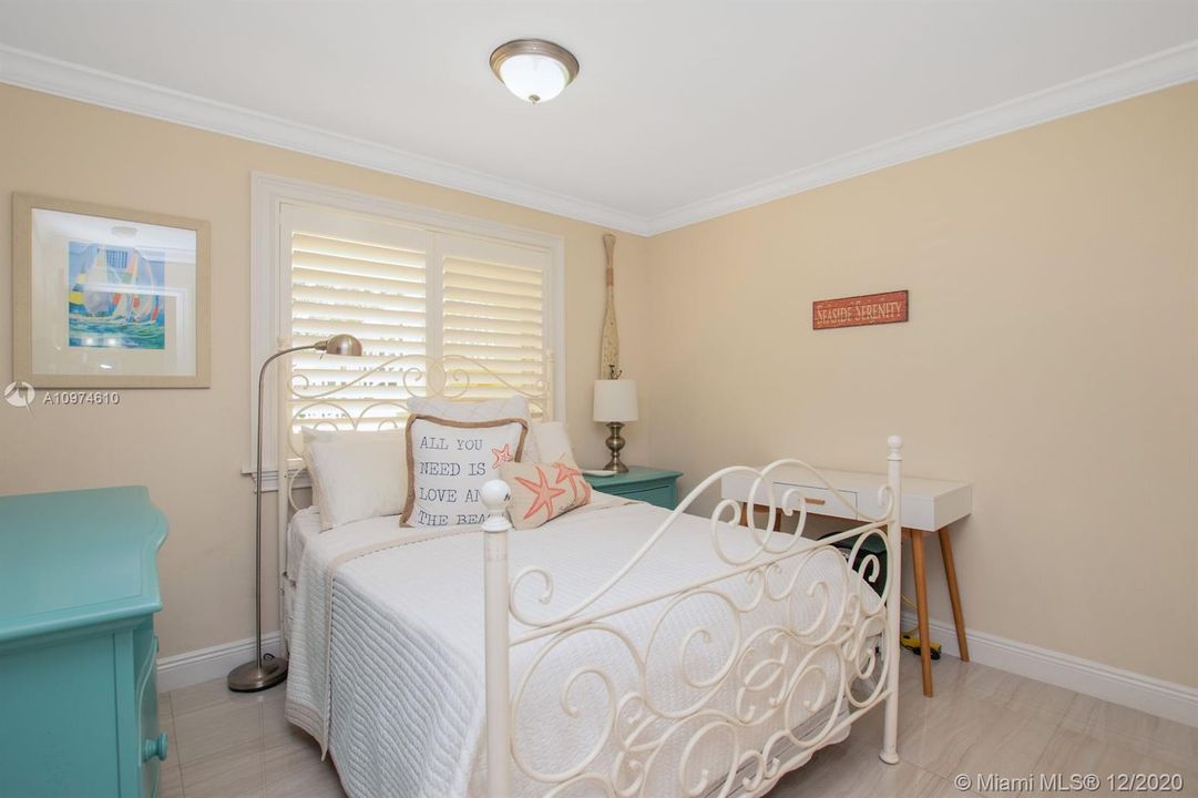 2nd Bedroom - plantation shutters, tile floors, crown molding