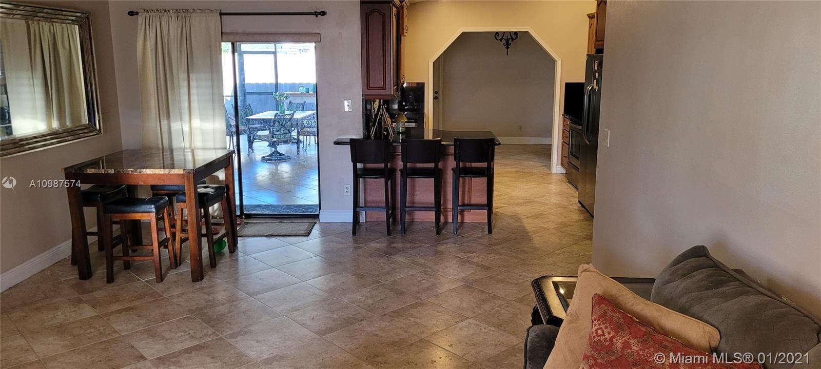 Family room adjacent to kitchen with breakfast bar & access to screened porch