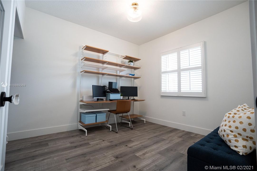 Approximately 11' x 10' 6" Guest room / Den includes modern solid wood doors including trim combined glass doorknobs, Hunter Douglas Plantation Shutters window treatments, 50 years warranty high density 7mm engineered look like wood vinyl flooring throughout and modern baseboards.