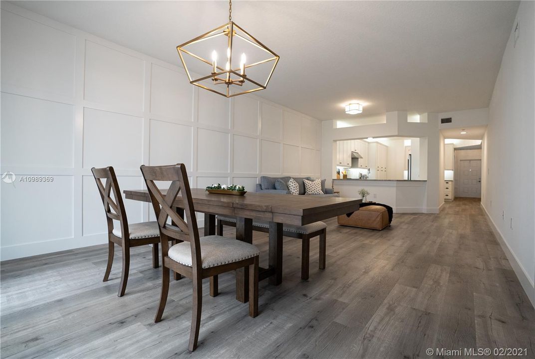 Great room showcases a Wood trim accent wall, baseboards and Farmhouse style light fixtures.   *Furniture not inlcuded but can be negotiated separetly.