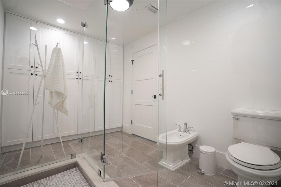 Master bathroom showcases frameless shower with wall to wall brand new cabinets, Kohler toilet and bidet Grohe Faucets, Porcelanosa Tiles, solidwood doors with trim combined glass doorknobs and modern baseboards.